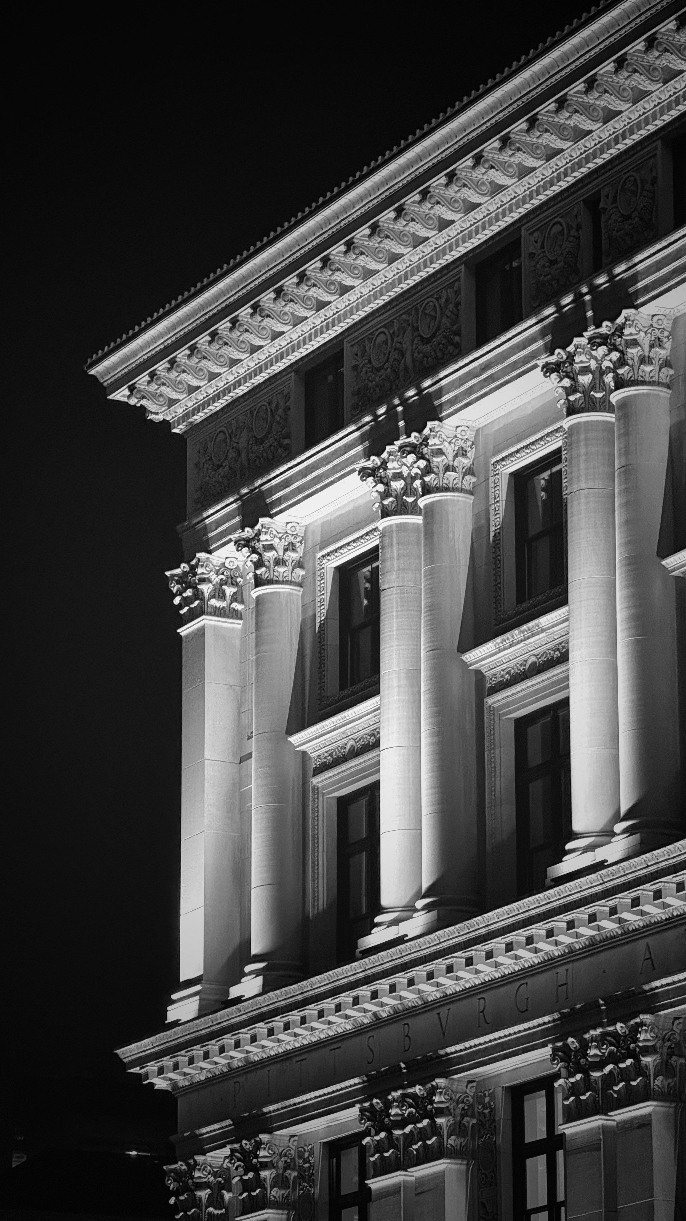 Ornate building facade with columns at night